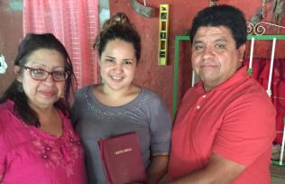 Pastors Handing Bible to Flores